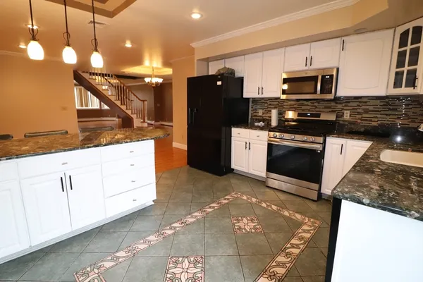 a kitchen with stainless steel appliances granite countertop a stove a sink and a refrigerator
