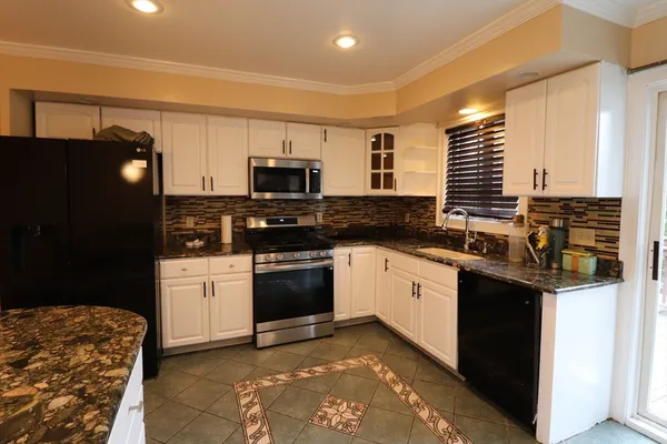 a kitchen with stainless steel appliances granite countertop a stove a sink and a refrigerator