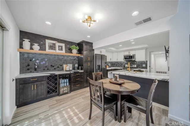 a kitchen with stainless steel appliances kitchen island granite countertop a table and chairs in it