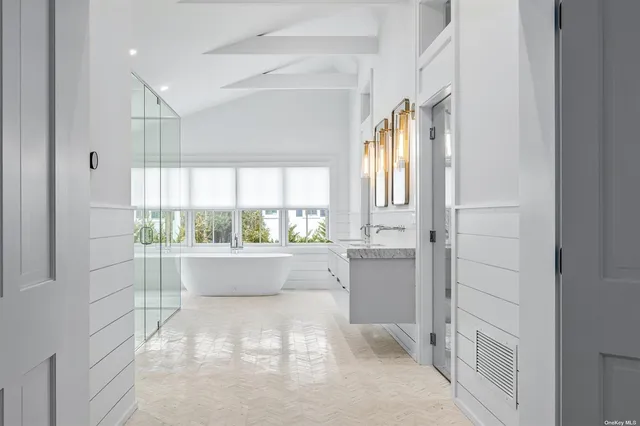 a large white kitchen with granite countertop a refrigerator and white cabinets