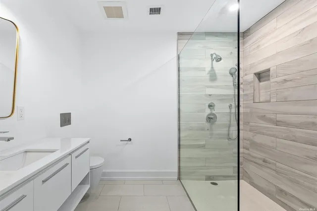 a bathroom with a granite countertop sink a shower and mirror
