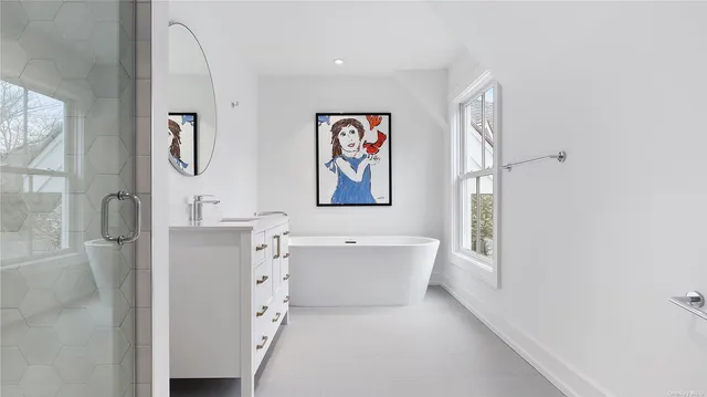 a bathroom with a tub sink and mirror