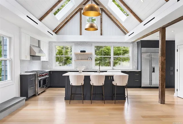 a kitchen with a stove a sink dishwasher a dining table and chairs with wooden floor