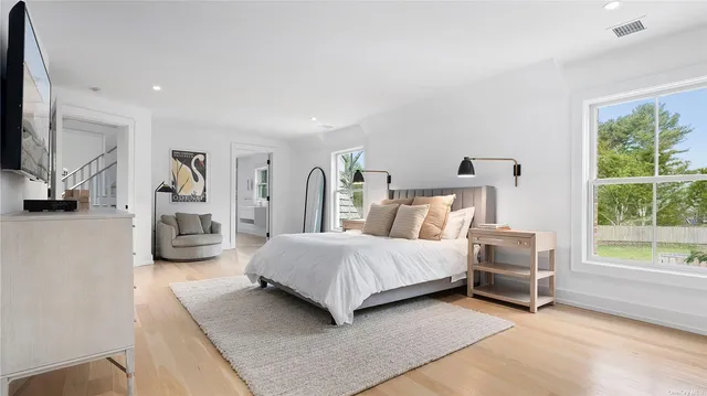 a bedroom with a bed a couch and large window