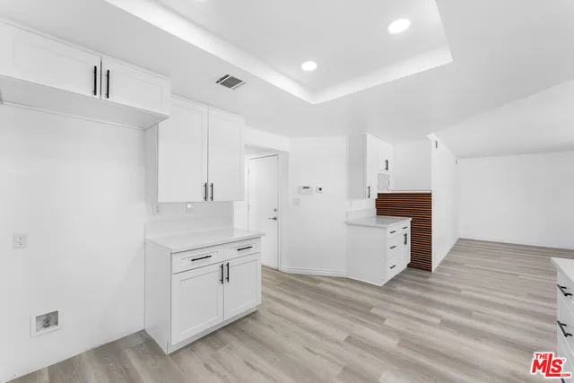 a kitchen with a sink cabinets and wooden floor