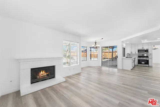 a view of a livingroom with wooden floor and a fireplace