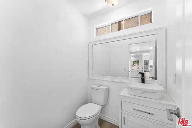 a bathroom with a toilet a sink a vanity and mirror