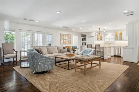 a living room with furniture kitchen view and a large window