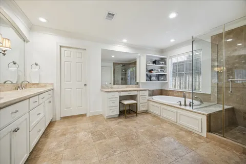 a bathroom with a granite countertop tub sink shower and mirror