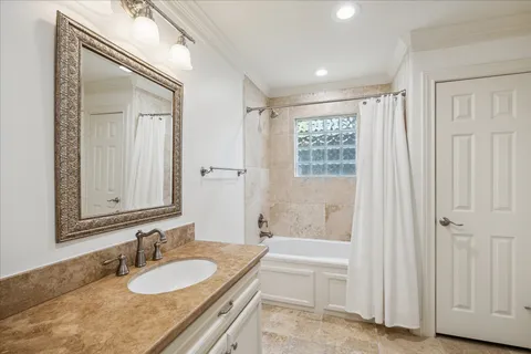 a bathroom with a granite countertop tub sink and mirror