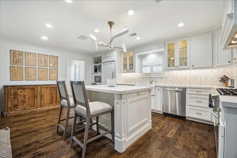 a kitchen with sink cabinets and dining table chair