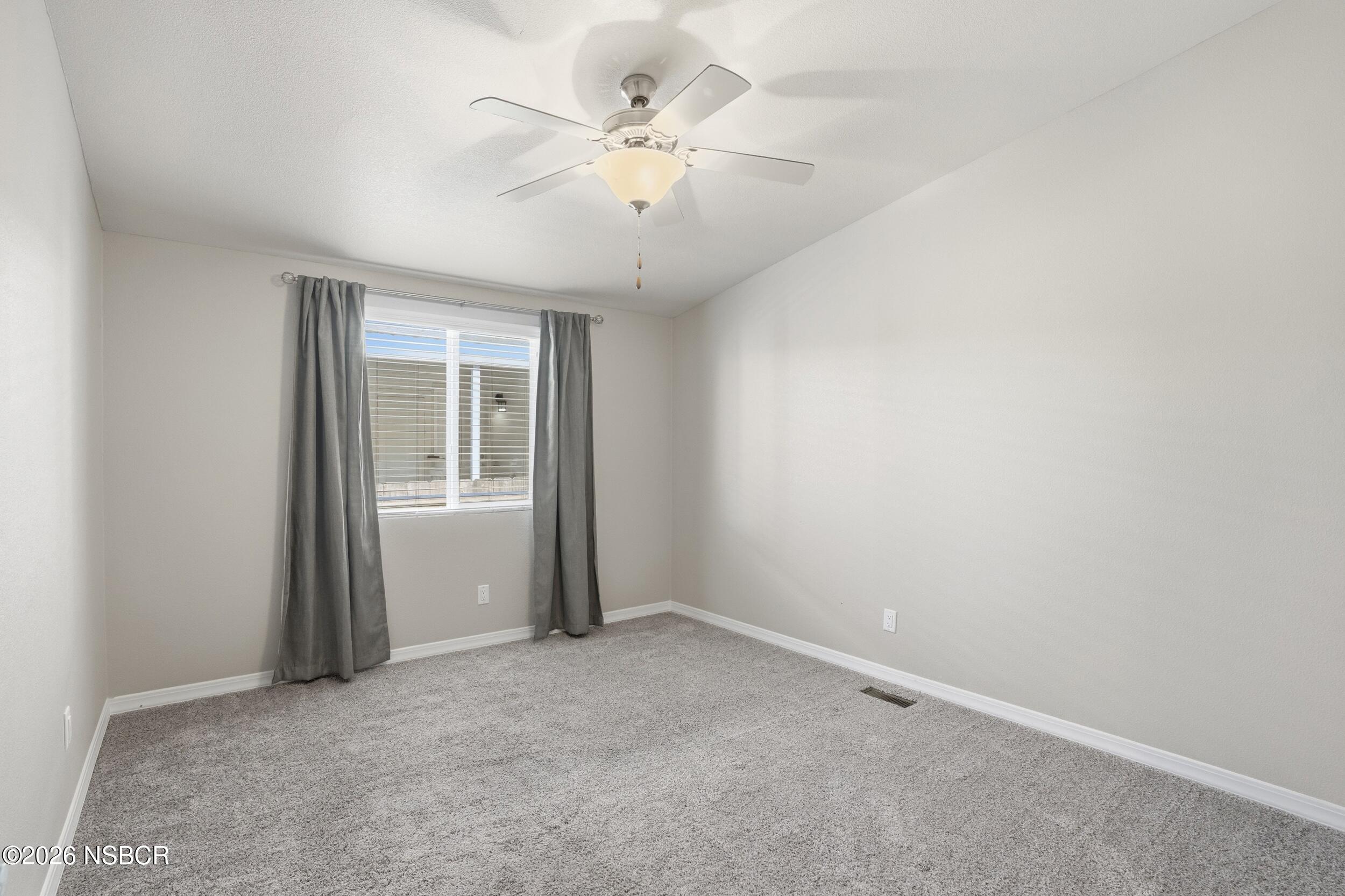 500 Atascadero Road, Unit M3 Morro Bay, CA 93442 - Photo 27 of 29 an empty room with chandelier fan and windows