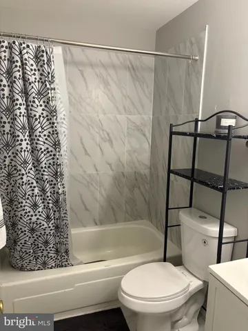 a white toilet sitting next to a bath tub