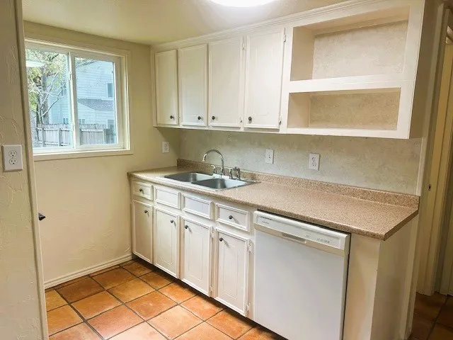 a kitchen with granite countertop white cabinets and white appliances