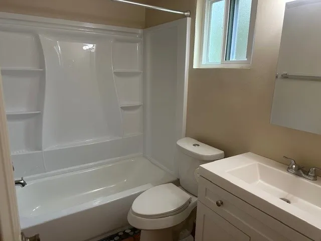 a white toilet sitting next to a bath tub