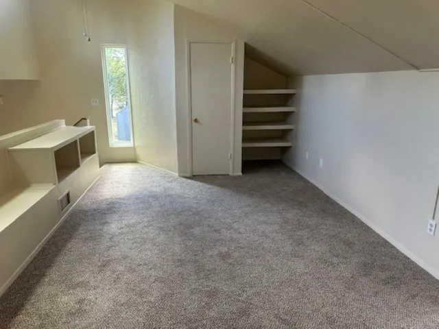 a view of an empty room with a fireplace and a window