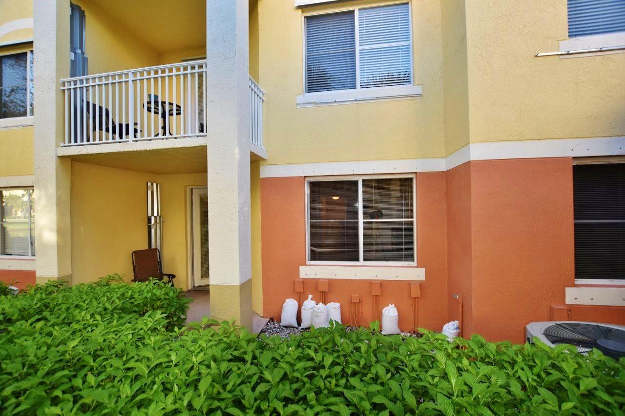 11016 Legacy Drive, Unit 103 Palm Beach Gardens, FL 33410 - Photo 12 of 44 a front view of a house with a yard