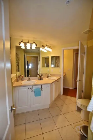 a large bathroom with a double vanity sink mirror and toilet