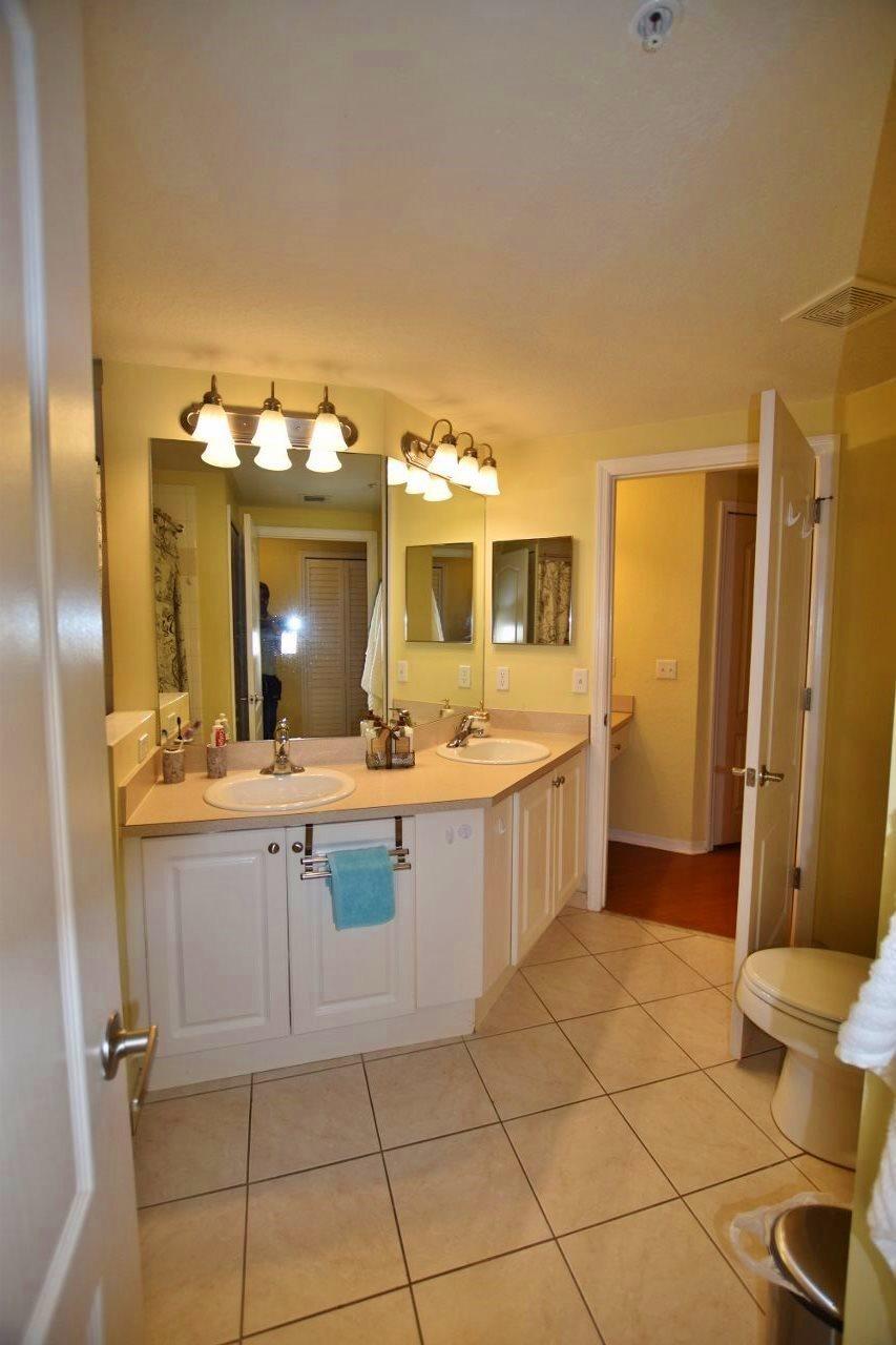 11016 Legacy Drive, Unit 103 Palm Beach Gardens, FL 33410 - Photo 17 of 44 a large bathroom with a double vanity sink mirror and toilet