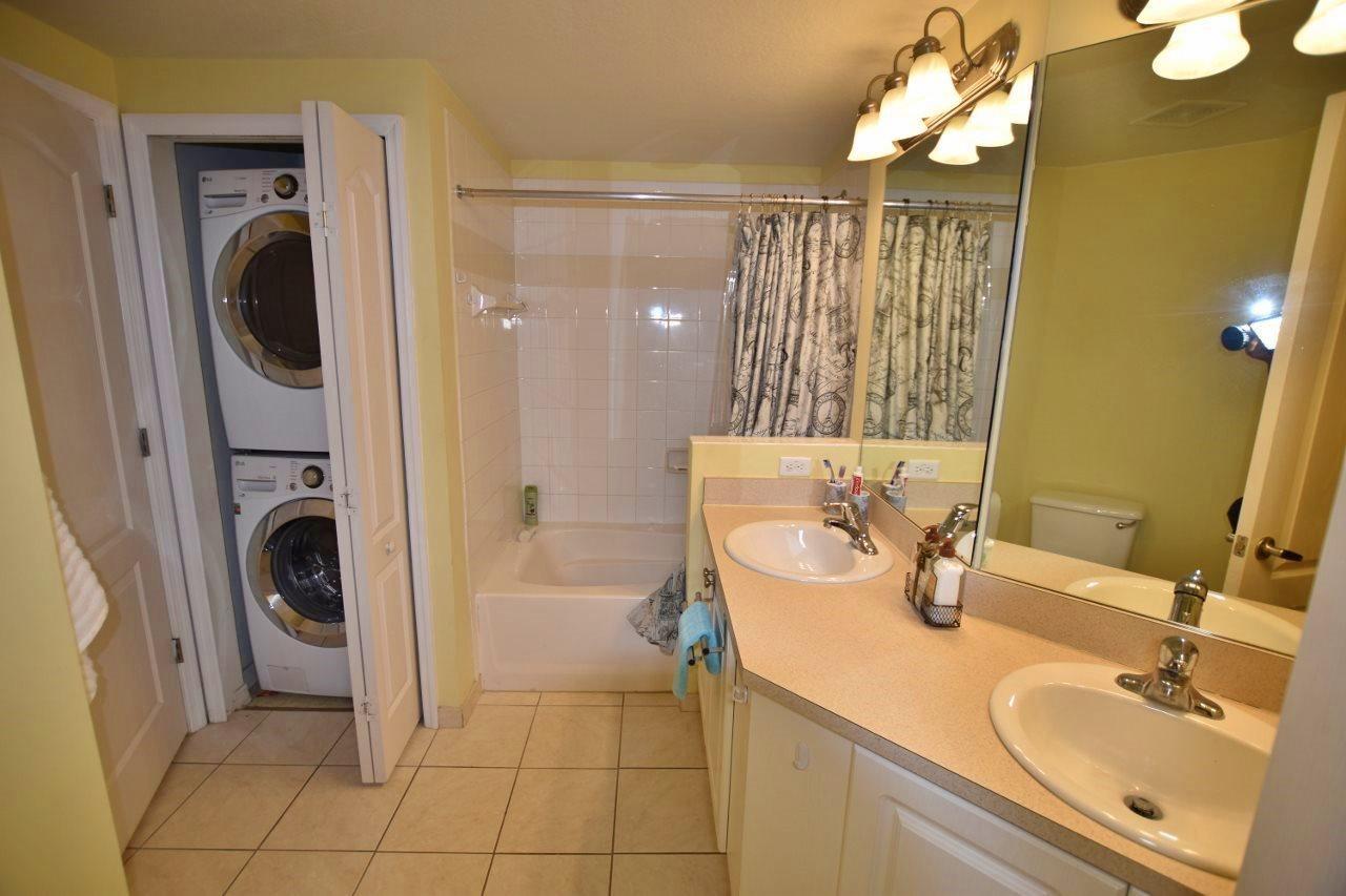 11016 Legacy Drive, Unit 103 Palm Beach Gardens, FL 33410 - Photo 20 of 44 a bathroom with a sink a washer and dryer mirror