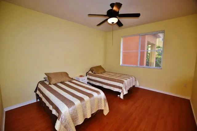 a bedroom with two beds and wooden floor