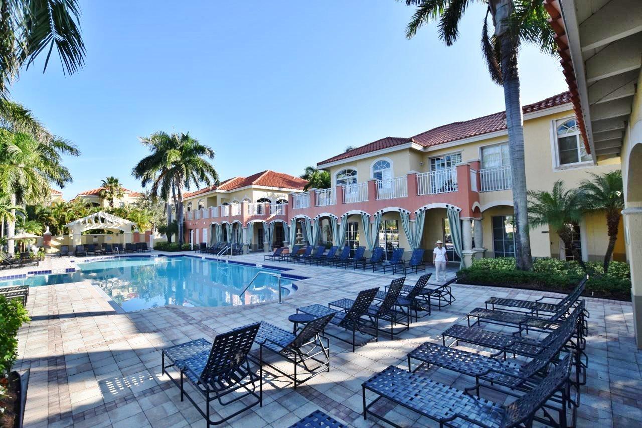 11016 Legacy Drive, Unit 103 Palm Beach Gardens, FL 33410 - Photo 26 of 44 a view of a patio with couches table and chairs with palm trees