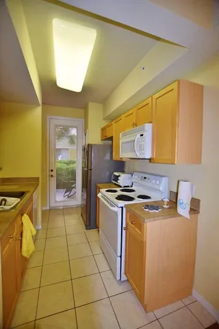 a kitchen with a stove top oven cabinets and a refrigerator