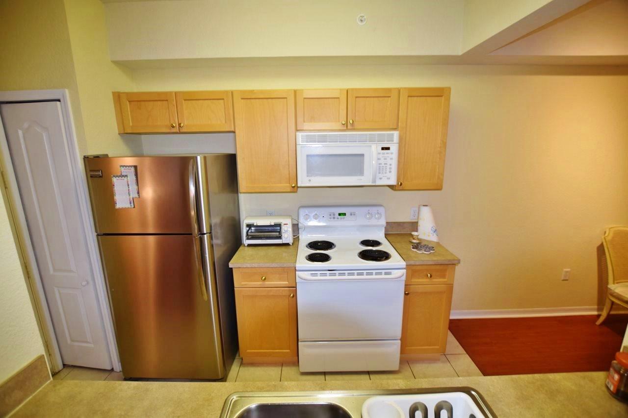 11016 Legacy Drive, Unit 103 Palm Beach Gardens, FL 33410 - Photo 9 of 44 a kitchen with a refrigerator sink and stove