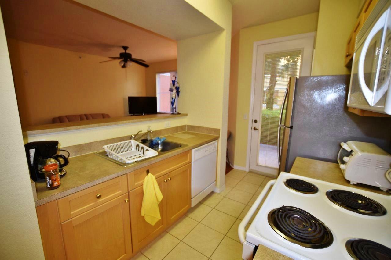 11016 Legacy Drive, Unit 103 Palm Beach Gardens, FL 33410 - Photo 10 of 44 a bathroom with a granite countertop sink and a washing machine