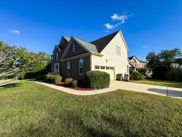 a view of backyard of house with green space