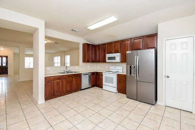 a kitchen with stainless steel appliances a refrigerator sink and cabinets