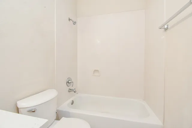 a white bath tub sitting next to a white toilet