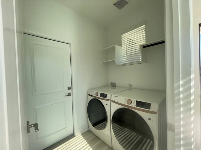 a view of an empty room and a kitchen