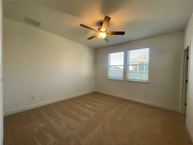 a view of an empty room and a kitchen