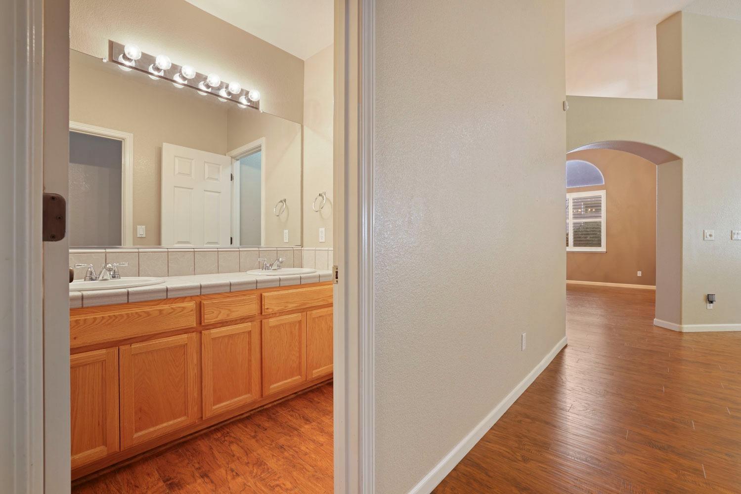 4316 Versailles Drive Modesto, CA 95356 - Photo 19 of 45 a bathroom with a double vanity sink and a mirror