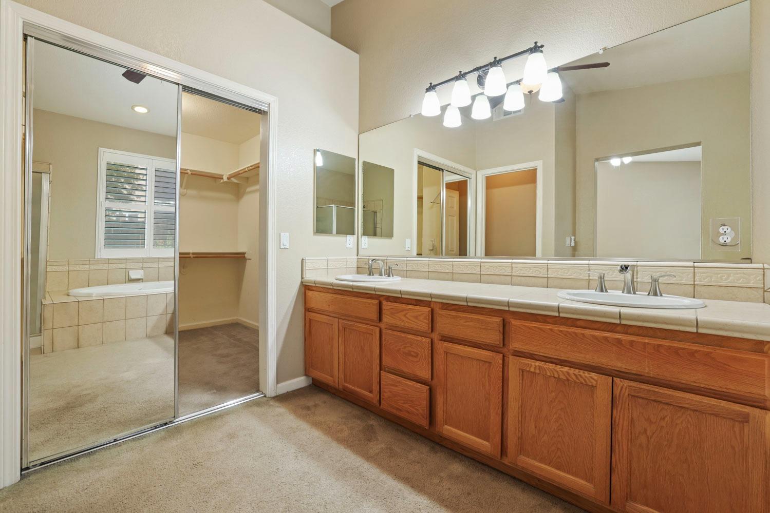 4316 Versailles Drive Modesto, CA 95356 - Photo 26 of 45 a spacious bathroom with a double vanity sink a large mirror and a shower