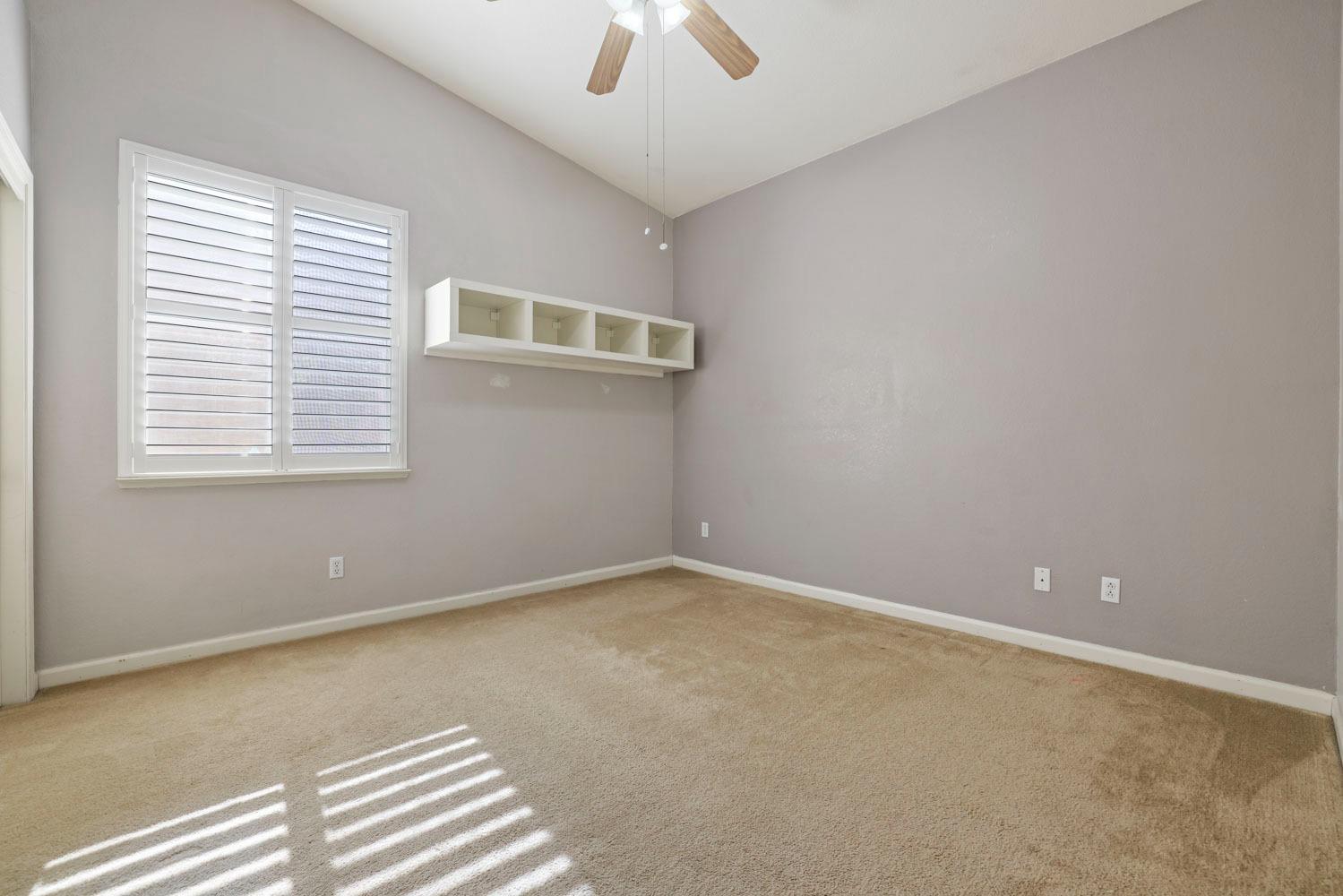 4316 Versailles Drive Modesto, CA 95356 - Photo 34 of 45 an empty room with a window and a ceiling fan