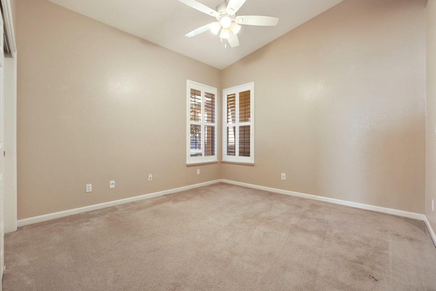 4316 Versailles Drive Modesto, CA 95356 - Photo 39 of 45 an empty room with windows and chandelier fan