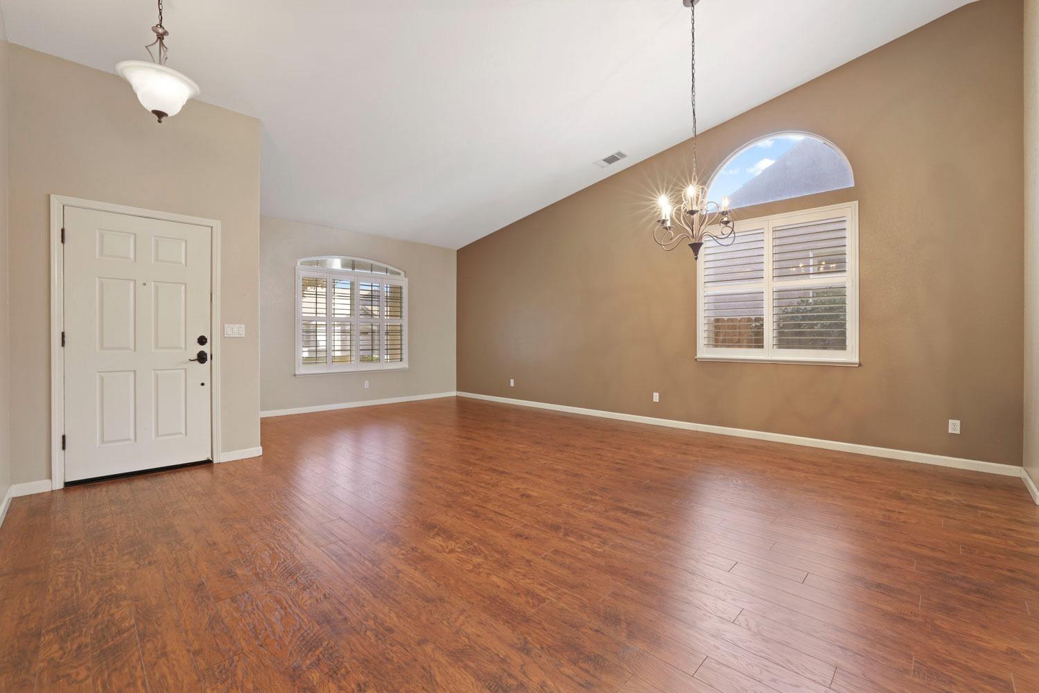 4316 Versailles Drive Modesto, CA 95356 - Photo 7 of 45 a view of an empty room with wooden floor and a window