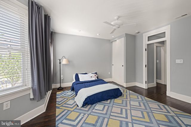 a bedroom with a bed and a large mirror next to a window