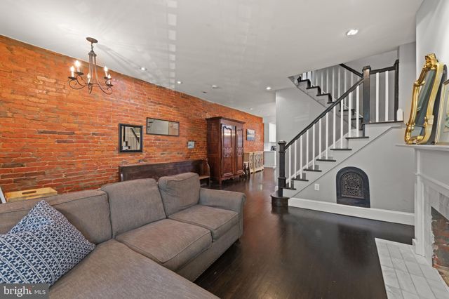 a living room with fireplace furniture and a wooden floor