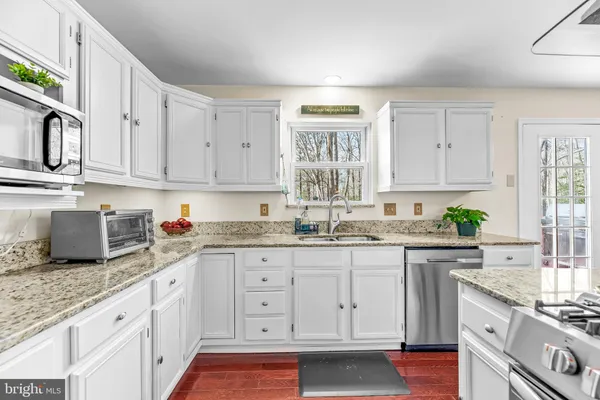 a kitchen with granite countertop white cabinets and white appliances
