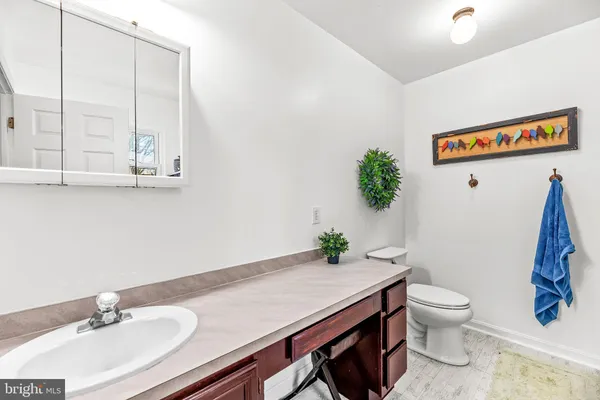 a bathroom with a granite countertop sink a toilet and a mirror