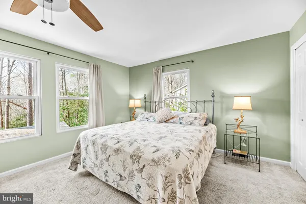 a bedroom with a bed a chandelier and a window