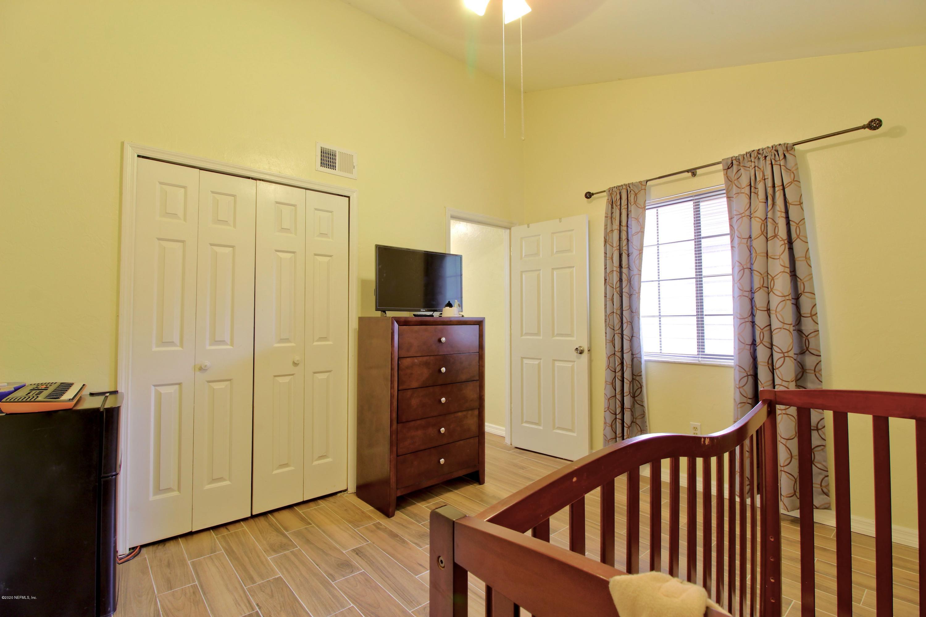 910 Southwest 57 Terrace Gainesville, FL 32607 - Photo 11 of 18 a bedroom with a bed and wooden floor