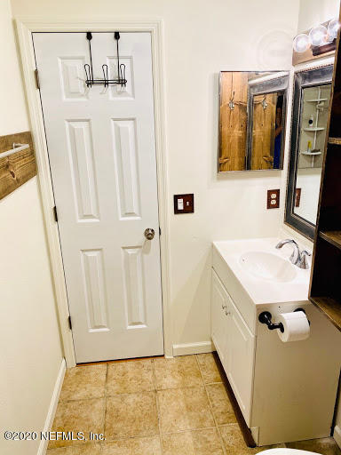 910 Southwest 57 Terrace Gainesville, FL 32607 - Photo 5 of 18 a bathroom with a sink a toilet and mirror