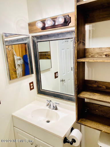 910 Southwest 57 Terrace Gainesville, FL 32607 - Photo 6 of 18 a bathroom with a sink and a mirror