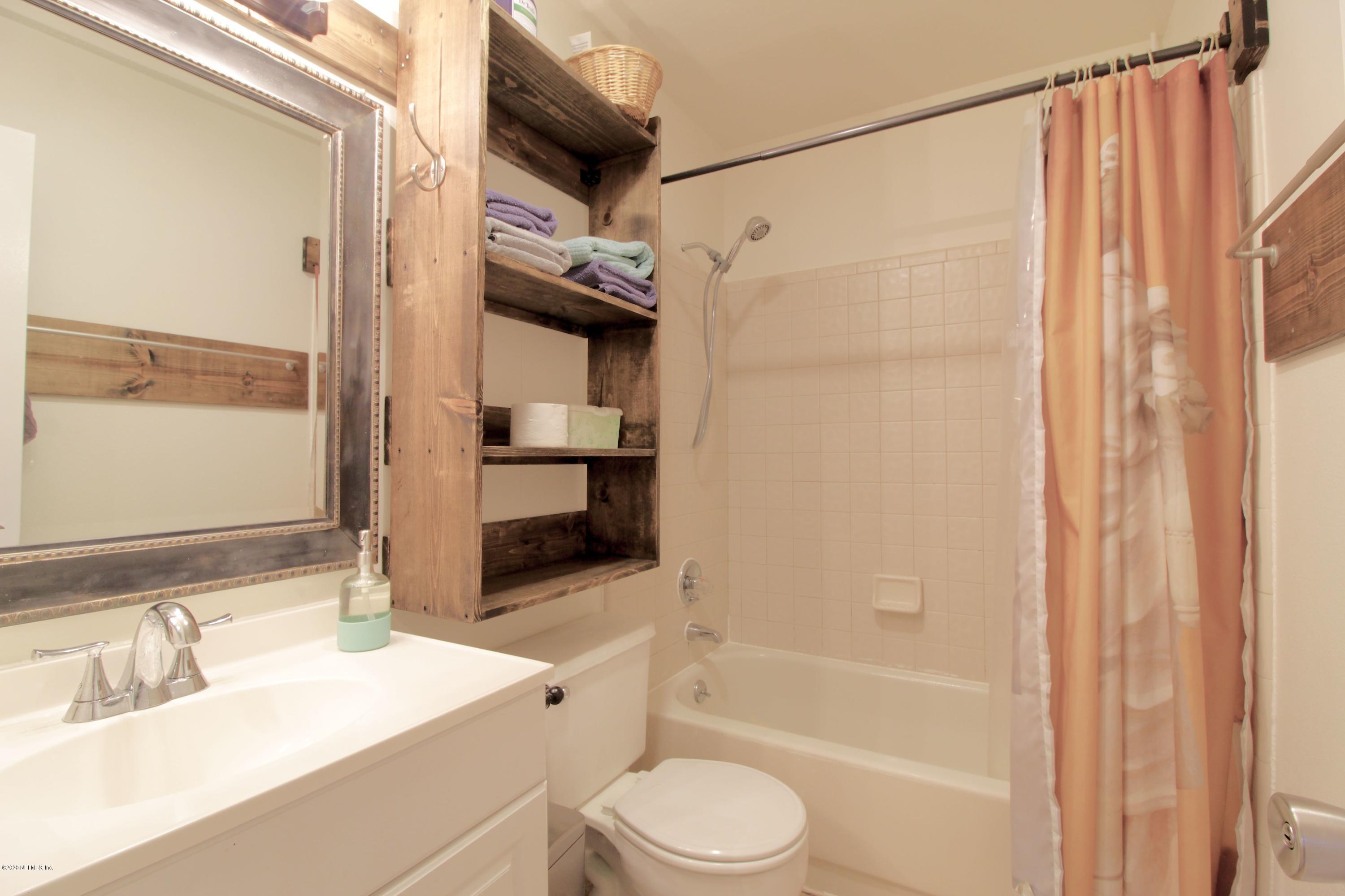 910 Southwest 57 Terrace Gainesville, FL 32607 - Photo 7 of 18 a bathroom with a sink a toilet and shower