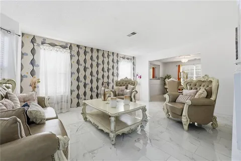 a kitchen with white cabinets and chandelier