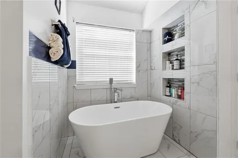 a bathroom with a bathtub a shower and a sink